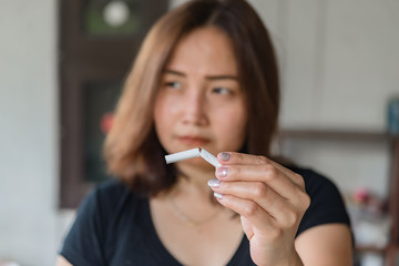 Asian woman hand crushing cigarette.Quitting from addiction concept,No tobacco day,No smoking concept