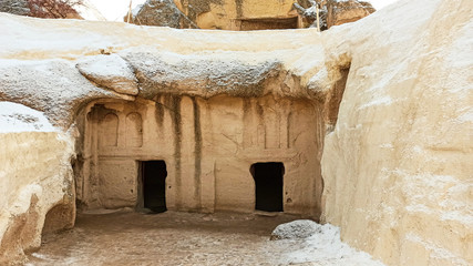 Ancient stone cave houses carved into the volcanic rock in Cappadocia, Turkey