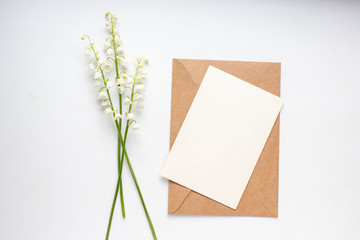Mockup with postcard and lilies of the valley on white background card and bouquet