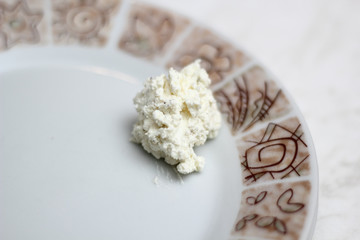 Small portion cottage cheese with ground black pepper on plate