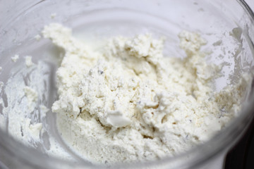 Cottage cheese with ground black pepper in glass bowl