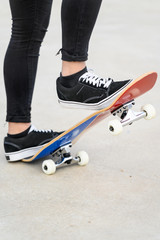 Close up view of teen's feet on a skateboard ready to start a ride over the half pipe . 