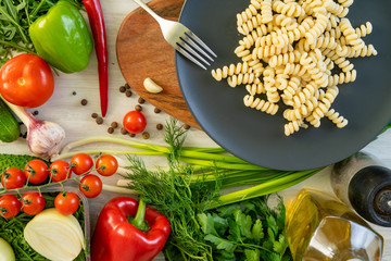 Eggplant, chilli and tomato penne pasta, on a black serving platter. Garnished with basil.