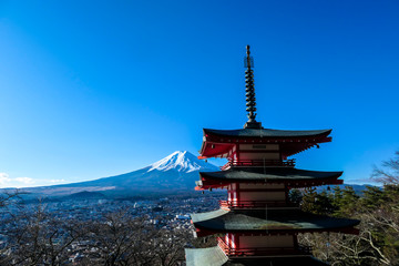 View on Chureito Pagoda and mountain of the mountains Mt Fuji, Japan, captured on a clear, sunny day in winter. Top of the volcano covered with snow. Trees aren't blossoming yet. Postcard from Japan.