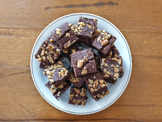 A delicious vegan brownie cut in cubes on a wooden table