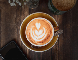 Top down image of a Latte and mobile phone showing the coffee culture or weekend lifestyle of millennials