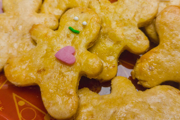 One gingerbread man has a pink heart, the rest of the cookies are empty. The concept of humanity, kindness, warmth. One against all. Being different concept