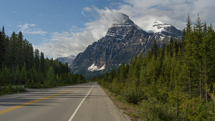 Fototapeta premium Road with snowcapped mountain range in the background, Icefield Parkway, Alberta, Canada