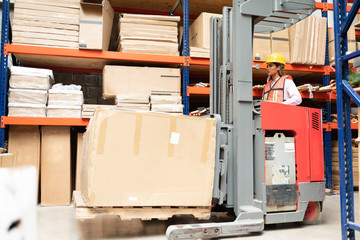 Young Supervisor Using Machinery At Warehouse