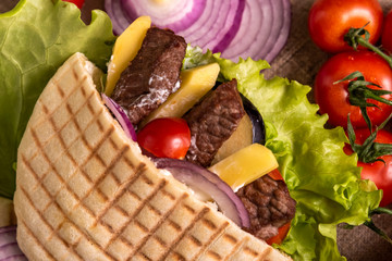 Pita doner kebab with green salad, potato free, tomatoes, cherry, cucumber and fried beef. Street...