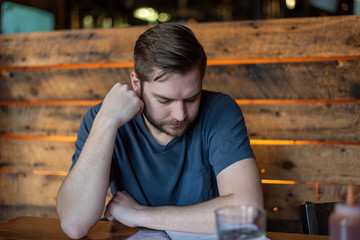 Obraz premium Young man looking at a menu at a craft brewery