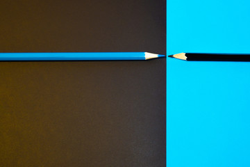 Black and blue pencil facing each other. Minimal Aesthetic.