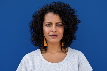 Content young woman standing against a colorful blue background