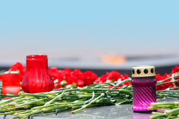Red carnations, candles of memory. Concept Victory Day, May 9. Copy space. Flower laying, eternal...