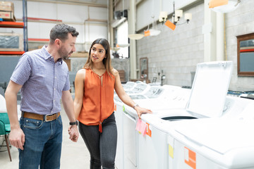 Couple In Casuals Standing By Washing Machine