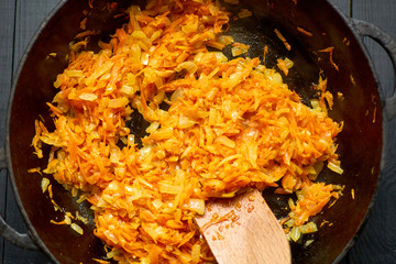Fry onions and carrots in a pan.
