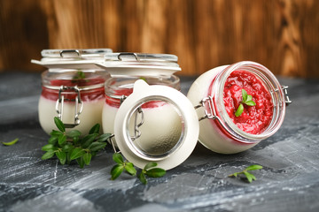 Classic italian dessert creamy panna cotta with cherry sauce on a dark rustic background copy space.