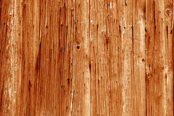 Naklejka premium Wall of vertical wooden weathered planks in orange tone.