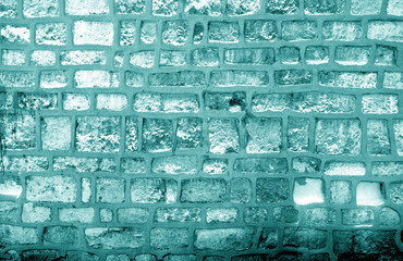 Wall made of old stones in cyan tone.