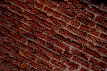 Decorative wall of destroyed dark red brick covered with varnish. Background for design on a construction or architectural theme
