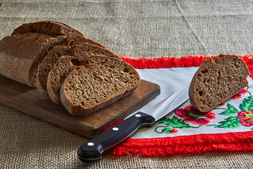 bread with knife and fork on wooden board