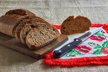 bread with knife and fork on wooden board