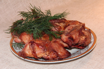 Fried quail with dill on a white plate. Tender dietary meat. Linen background.