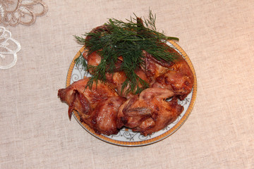 Fried quail with dill on a white plate. Tender dietary meat. Linen background.