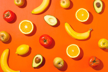 Fruits and vegetables on a bright background in hard light. Vegetarianism and healthy food concept.