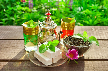 Moroccan mint tea in a sunny garden on a wooden table.