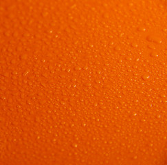 Wet orange background. Bright texture with water drops.