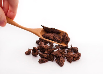 Dried puer tea heap with scoop in hand isolated on a white background.