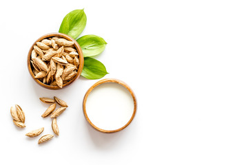 Alternative milk made from almond. Drink near unpeeled on white table top-down copy space