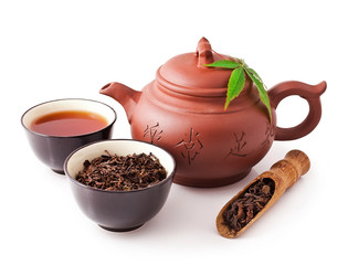 Chinese tea ceremony. Clay teapot with bowls and scoop of puer tea isolated on a white background.