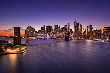 Brooklyn Bridge over the East River and the Manhattan downtown city skyline at night in New York USA