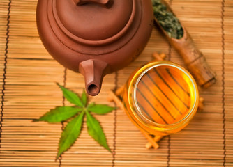 Chinese tea ceremony with dry green tea in spoon on a bamboo background. Top view.