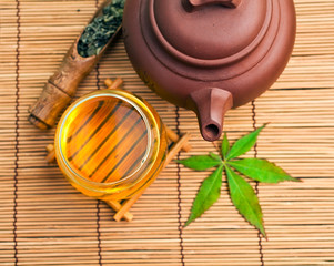 Chinese tea ceremony with dry green tea in spoon on a bamboo background. Top view.