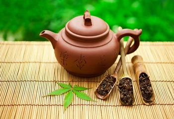 Foto op Aluminium Chinese tea ceremony in the garden with dry green tea in scoop and green maple leaf on a bamboo table. © Snowbelle