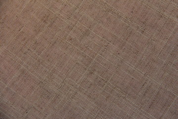Fototapeta na wymiar Linen beige background. The direction of the thread is diagonal. The texture of the linen fibers.