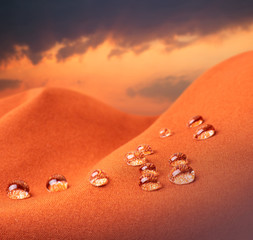 Waterproof fabric with water drops close up against the backdrop of cloudy sunrise