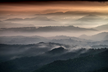 Paisaje de cerros de montañas entre la bruma al amanecer (Cataluña, España).