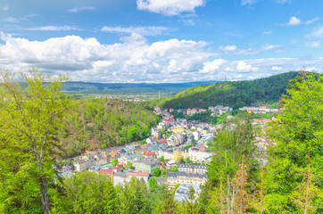 Karlovy Vary (Carlsbad) historical city centre top aerial view with colorful beautiful buildings, Slavkov Forest hills with green trees and Ore Mountain range background, West Bohemia, Czech Republic