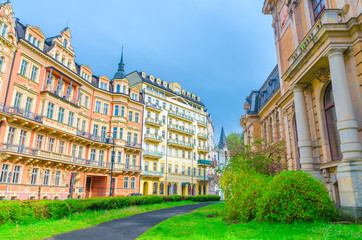 Fototapeta premium Karlovy Vary (Carlsbad) historical city centre with colorful beautiful traditional buildings, Kaiserbad Spa Imperial Bath or Lazne I, lawn with green grass and bushes, West Bohemia, Czech Republic