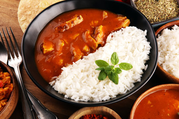 Chicken tikka masala spicy curry meat food in pot with rice and naan bread. indian food on table