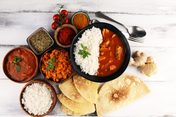 Chicken tikka masala spicy curry meat food in pot with rice and naan bread. indian food on table