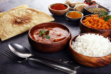 Chicken tikka masala spicy curry meat food in pot with rice and naan bread. indian food on table