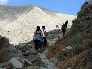 People Walking the Path to Ancient Thira. Panoramic view of Santorini island from the top of Mesa Vouno Mountain.