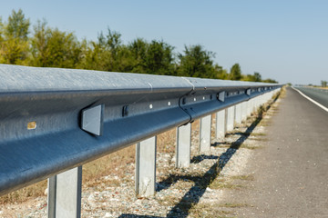 white road reflectors along the road. metal road fencing of barrier type. Road and traffic safety.