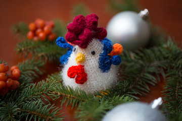 New Year 2017 symbol - handmade rooster with fir branches and cranberry