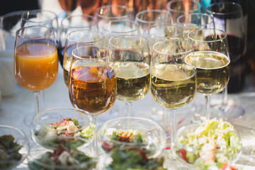 Reception at the wedding. Snacks and wine glasses on a glass table.